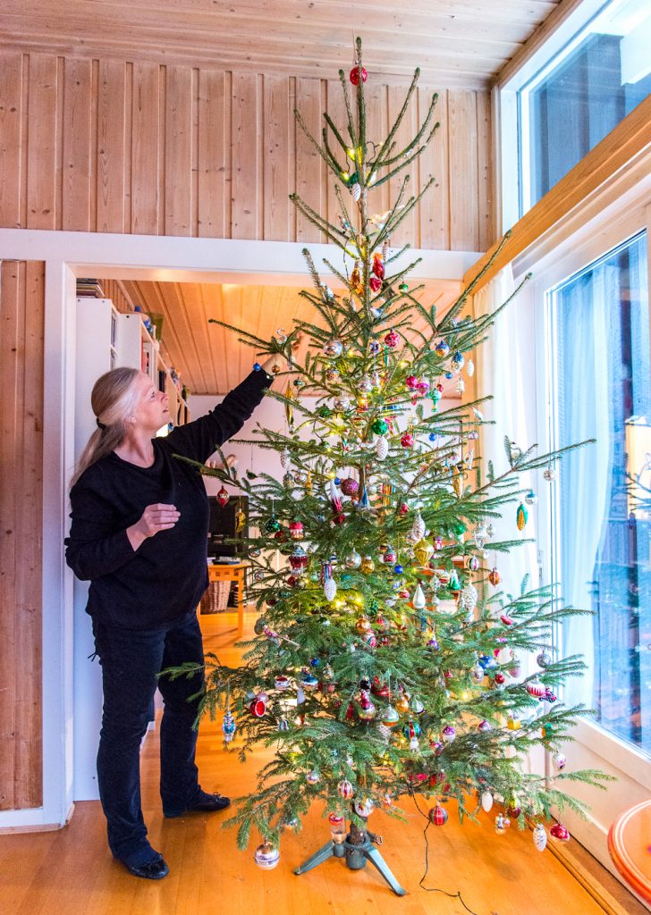 Familien bruker mange timer på å pynte treet, som rekker helt opp til taket.