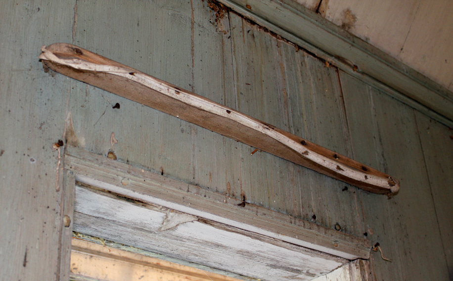 Dette er ett av de originale gardinbrettene i lysthuset. Gardinen ble festet med knappenåler i et bendelbånd som er spent opp i front på brettet. Foto: Rina Nysethbakken